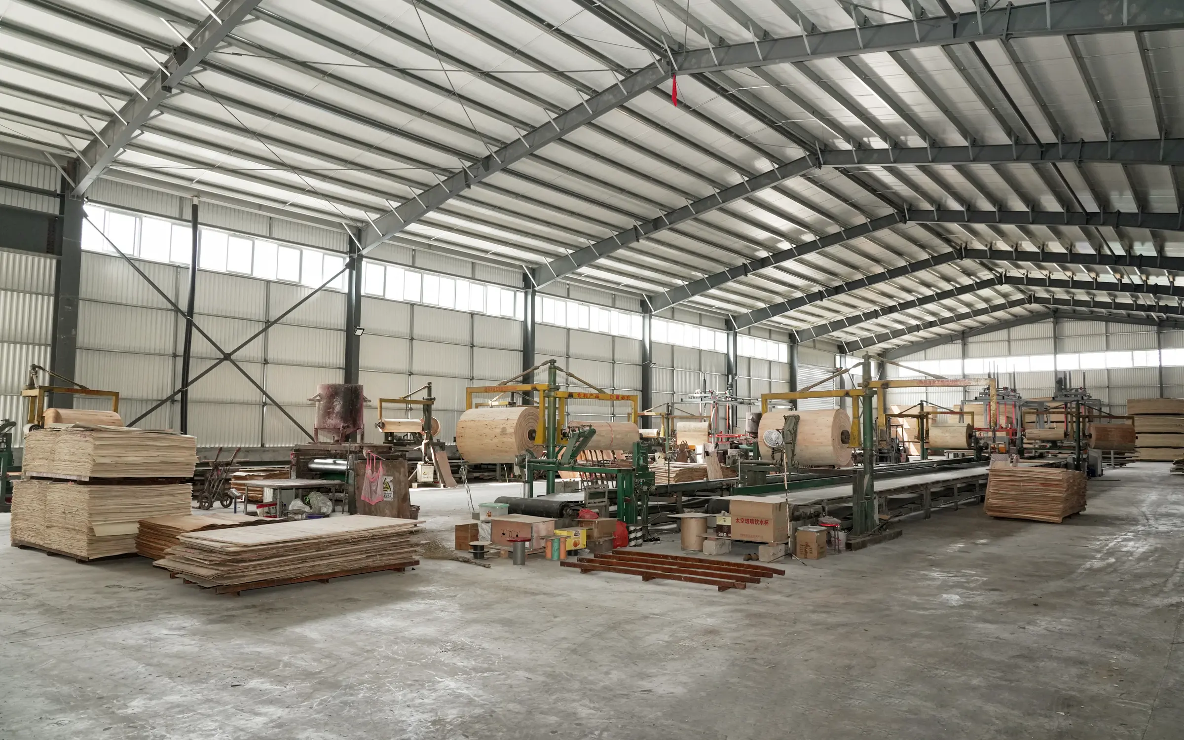 Multiple core veneer preparation lines arranged across a large factory workshop